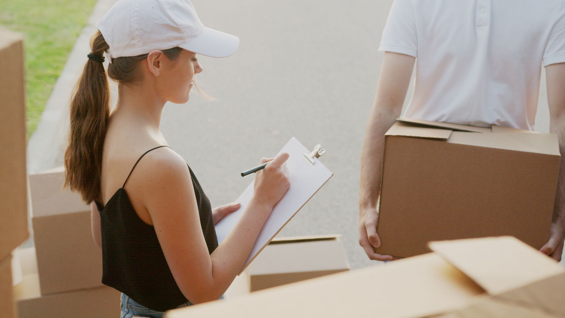 Courier team reviewing delivery checklist and handling packages. Efficient logistics management.