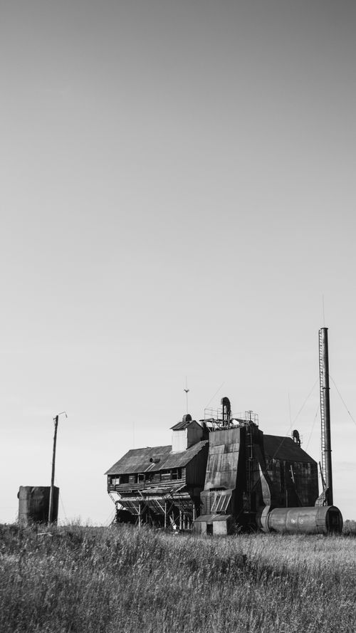 Free Black and white photo of an abandoned industrial building in the countryside with clear skies. Stock Photo