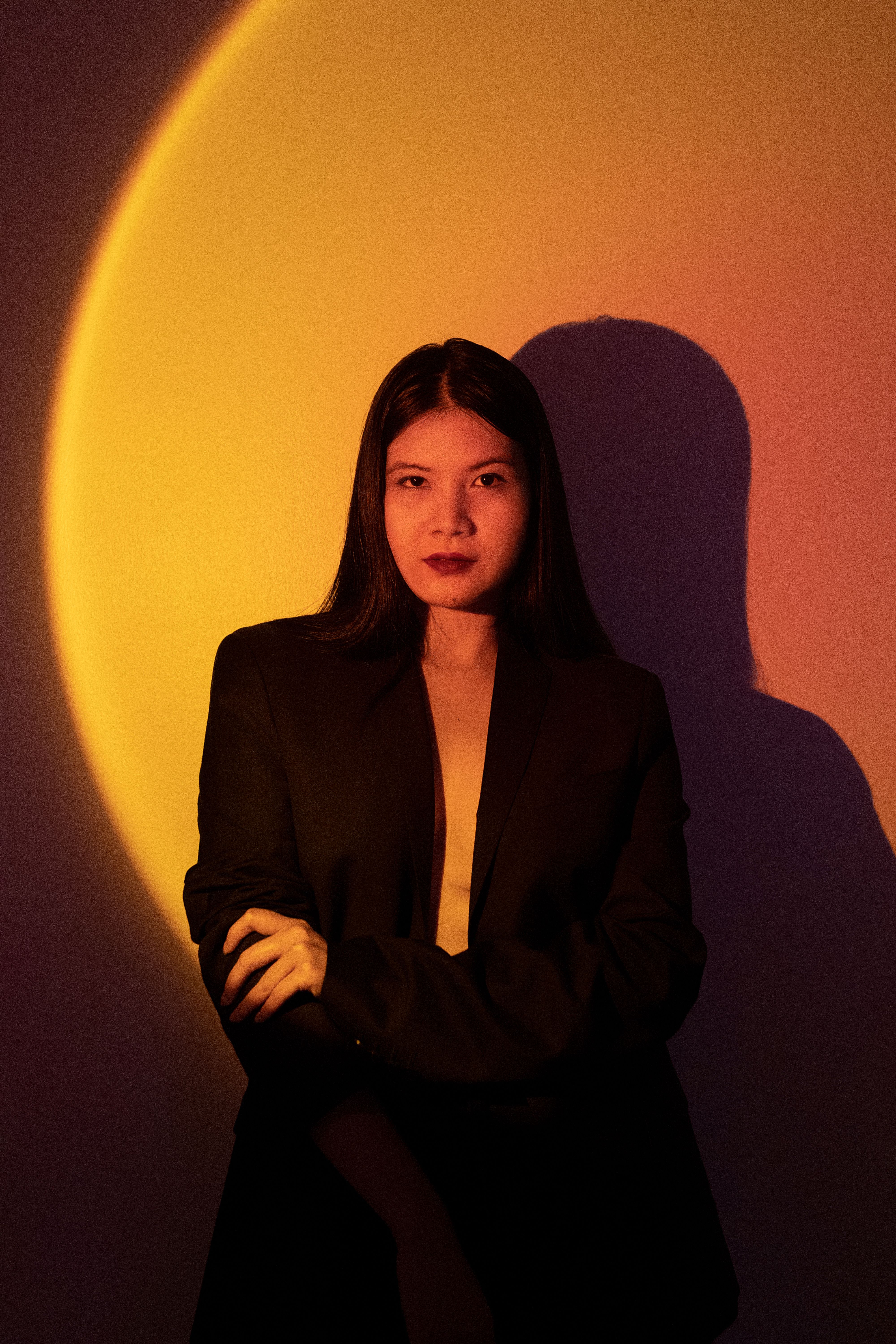 Stylish female portrait under dramatic lighting with black blazer.