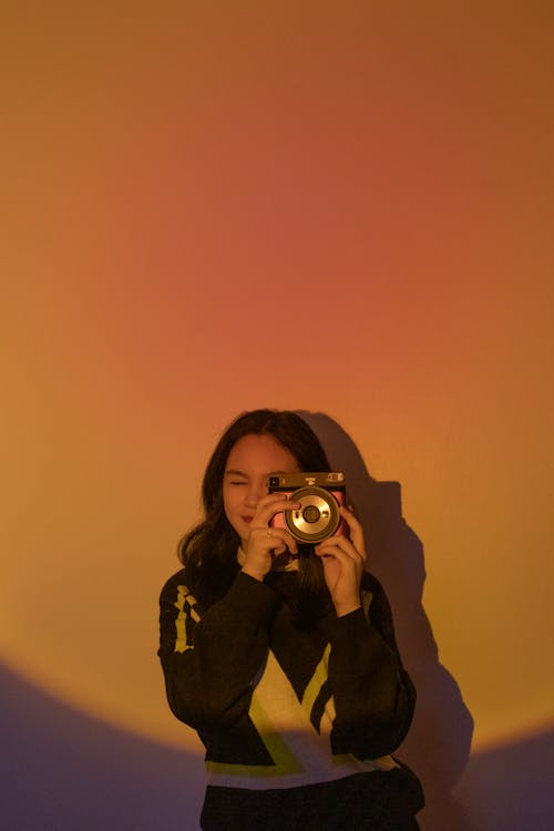 A Young Woman Taking Photos Using a Camera
