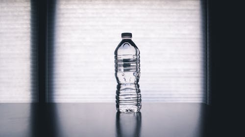 Gratis Botella Transparente Desechable Sobre Superficie Negra Foto de stock