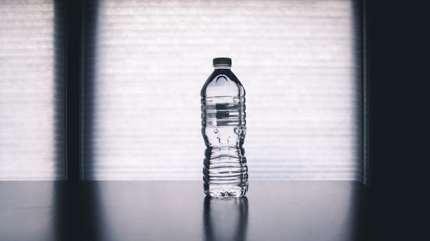 Clear Disposable Bottle on Black Surface. image used in tip to stop buying bottled water in my Small Ways to Save Money