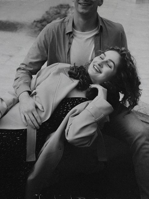 Happy couple embracing outdoors in black and white, showcasing love and relaxation.