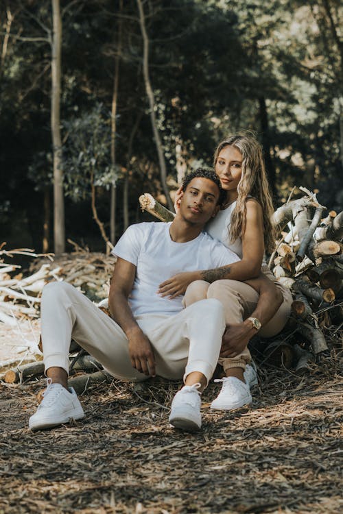 A Couple Hugging While Sitting on the Ground