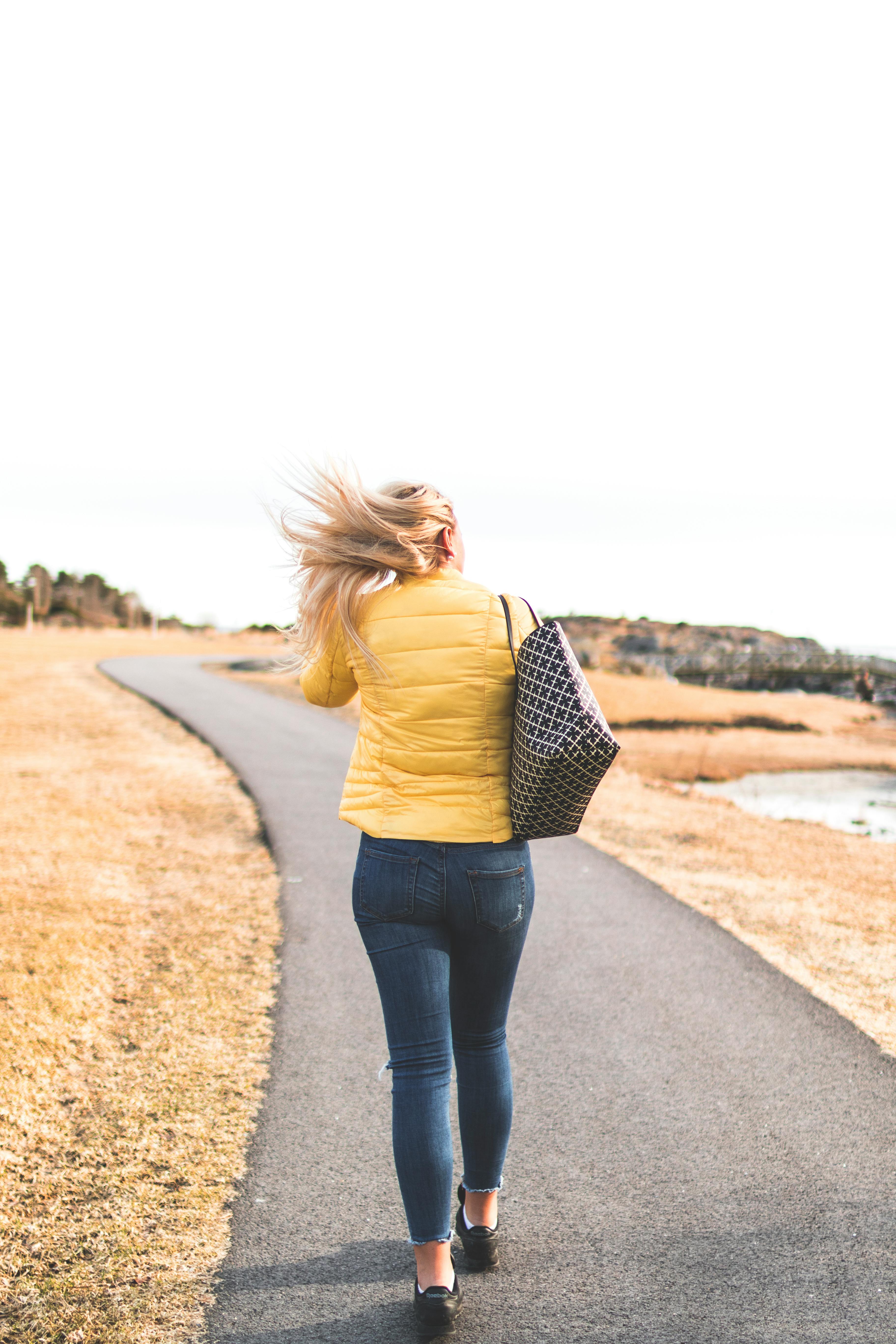 Woman Wears Yellow Bubble Jacket Walk Through Gray Asphalt Way · Free ...