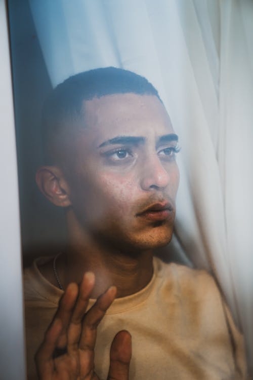 Portrait of Black Haired Man Looking Through Window