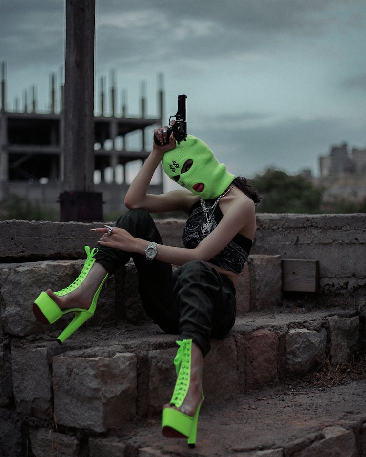 Woman Wearing Green Mask Holding A Gun