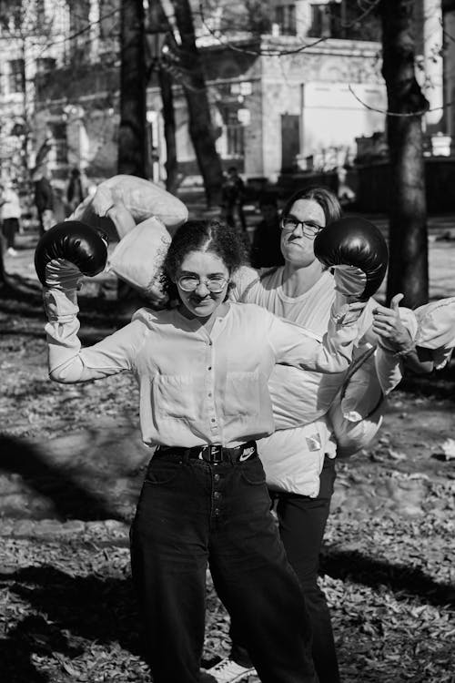 Grayscale Photo of Man Holding a Pillow and Girl Wearing Gloves 