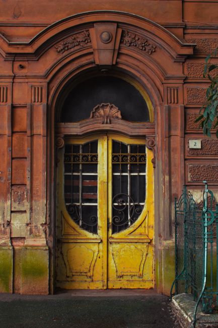 An ornate yellow door with intricate details in Pula, Croatia, showcasing vintage European architecture.