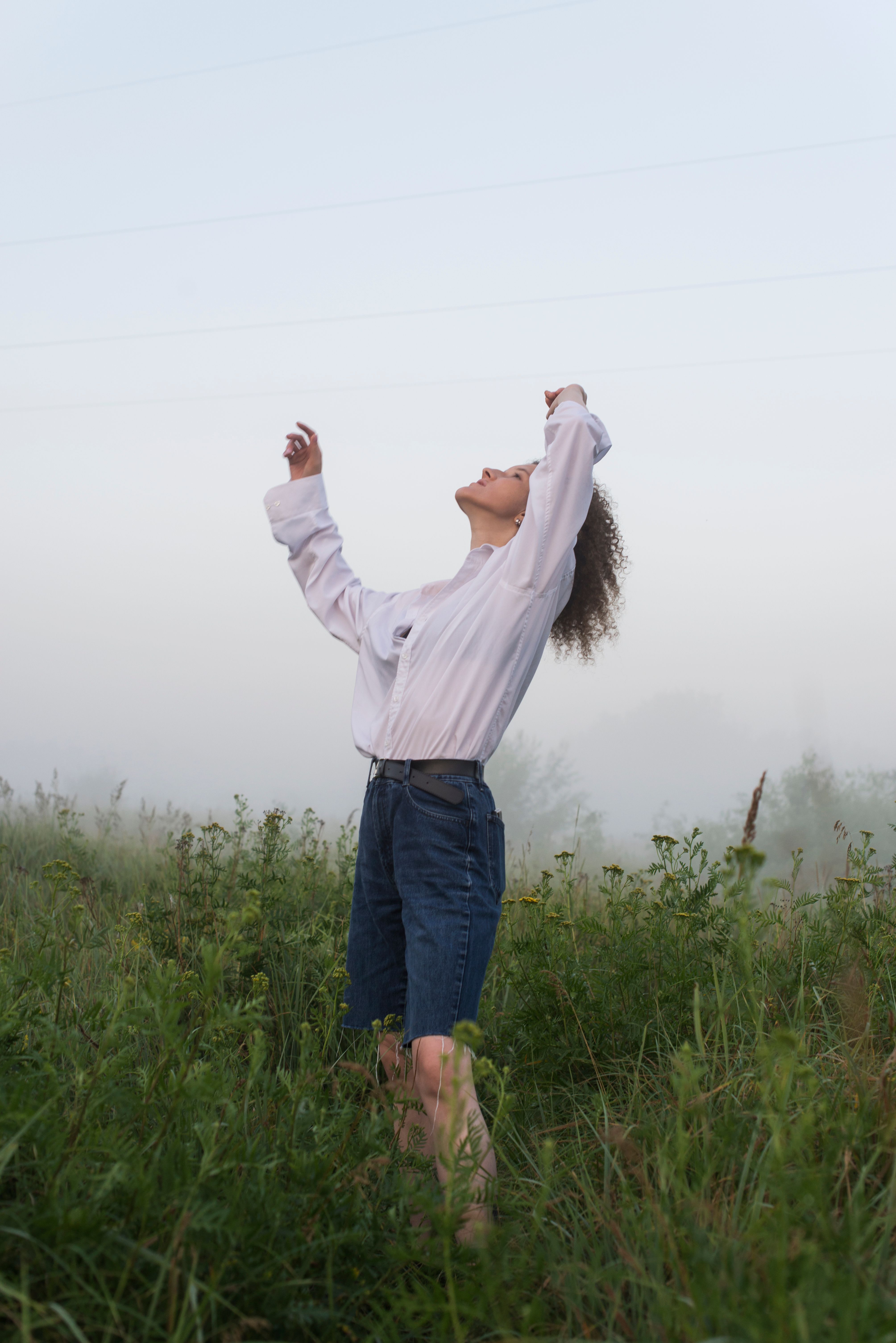 Woman in White Long Sleeves Shirt Standing on Green Grass Field · Free ...