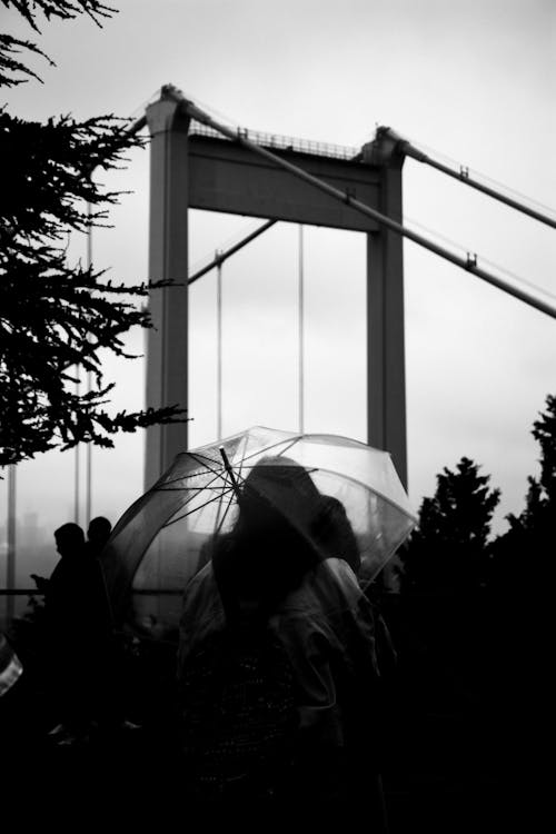 Grayscale Photo of a Person Under an Umbrella