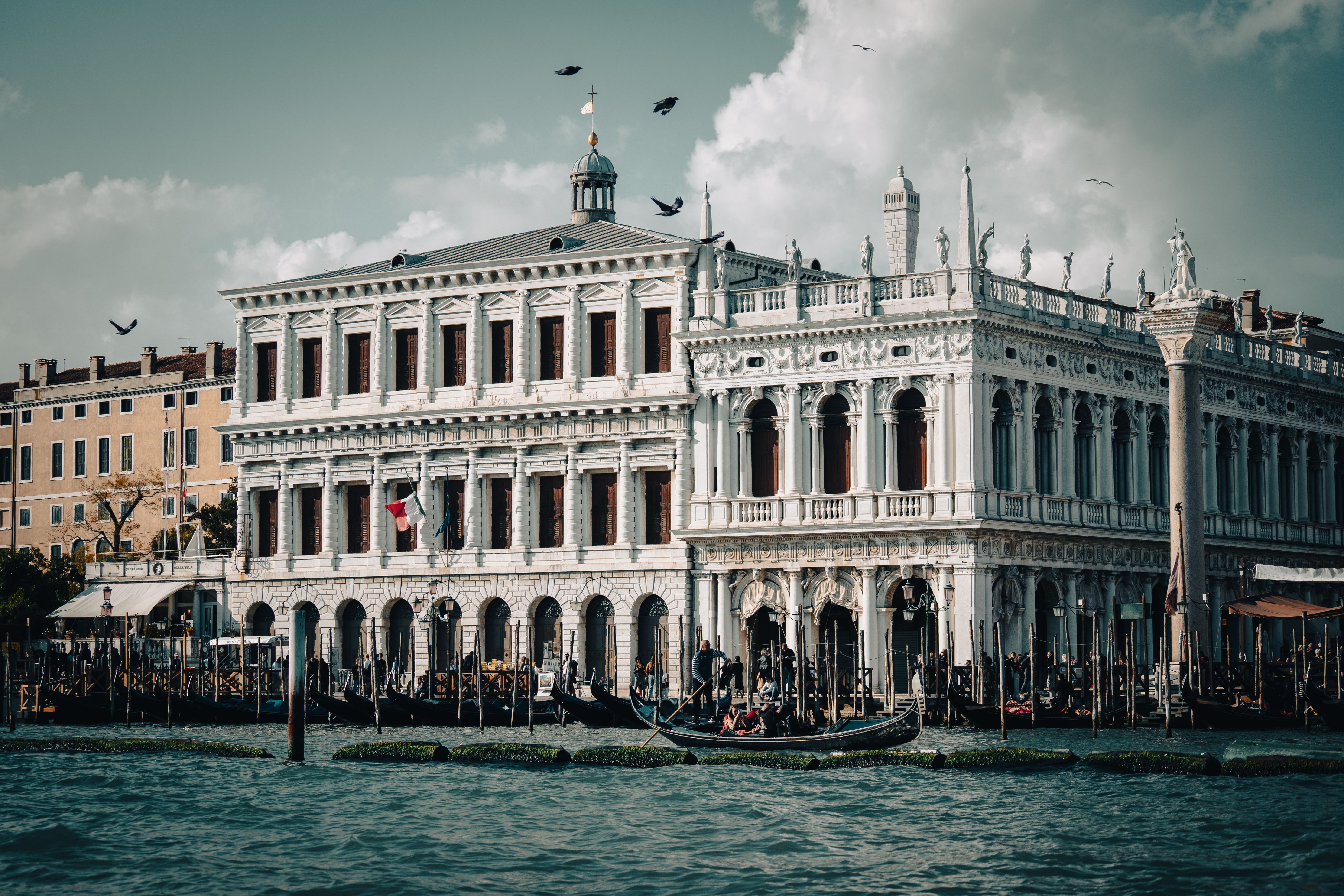 Elegant Venetian building by a bustling canal with gondolas, showcasing iconic architecture and vibrant tourism. Elegant Venetian building by a bustling canal with gondolas, showcasing iconic architecture and vibrant tourism.