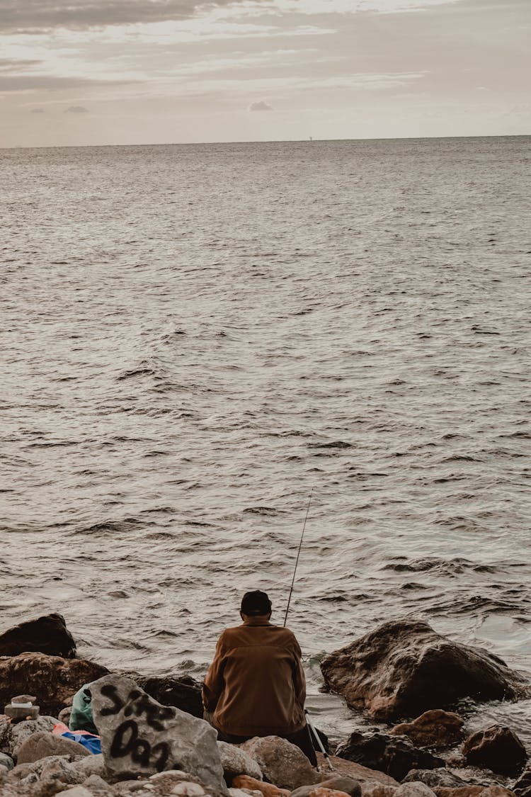 Man Fishing On Sea Shore