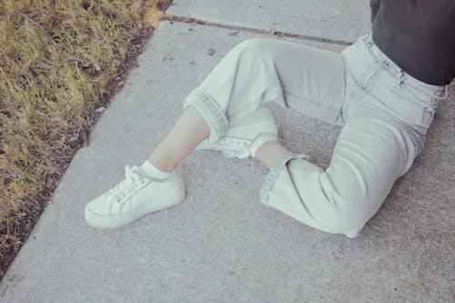 Бесплатное стоковое фото с белые туфли, бетонный пол, джинсовые брюки