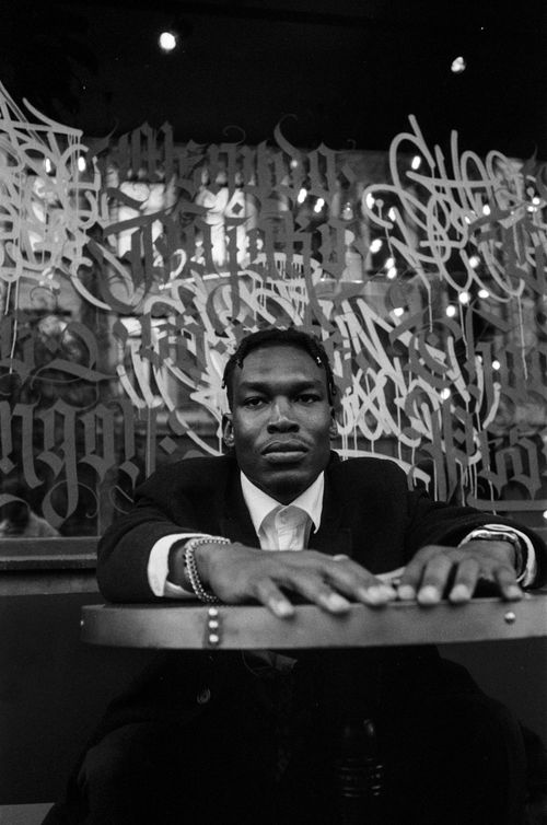 Free Emotive black and white photo of a man in a suit sitting at a table. Stock Photo