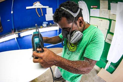 Man Using a Grinder in a Workshop 