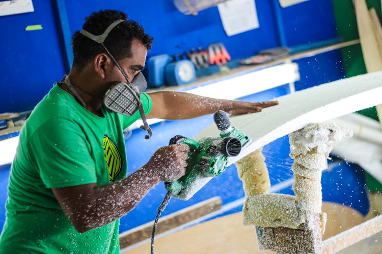 Carpenter In Protective Gear Cutting Wood