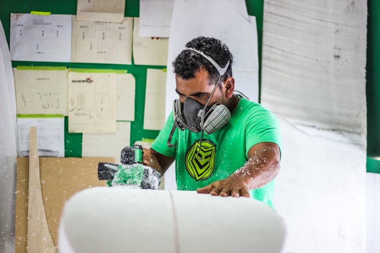 Man Sanding A Surfboard