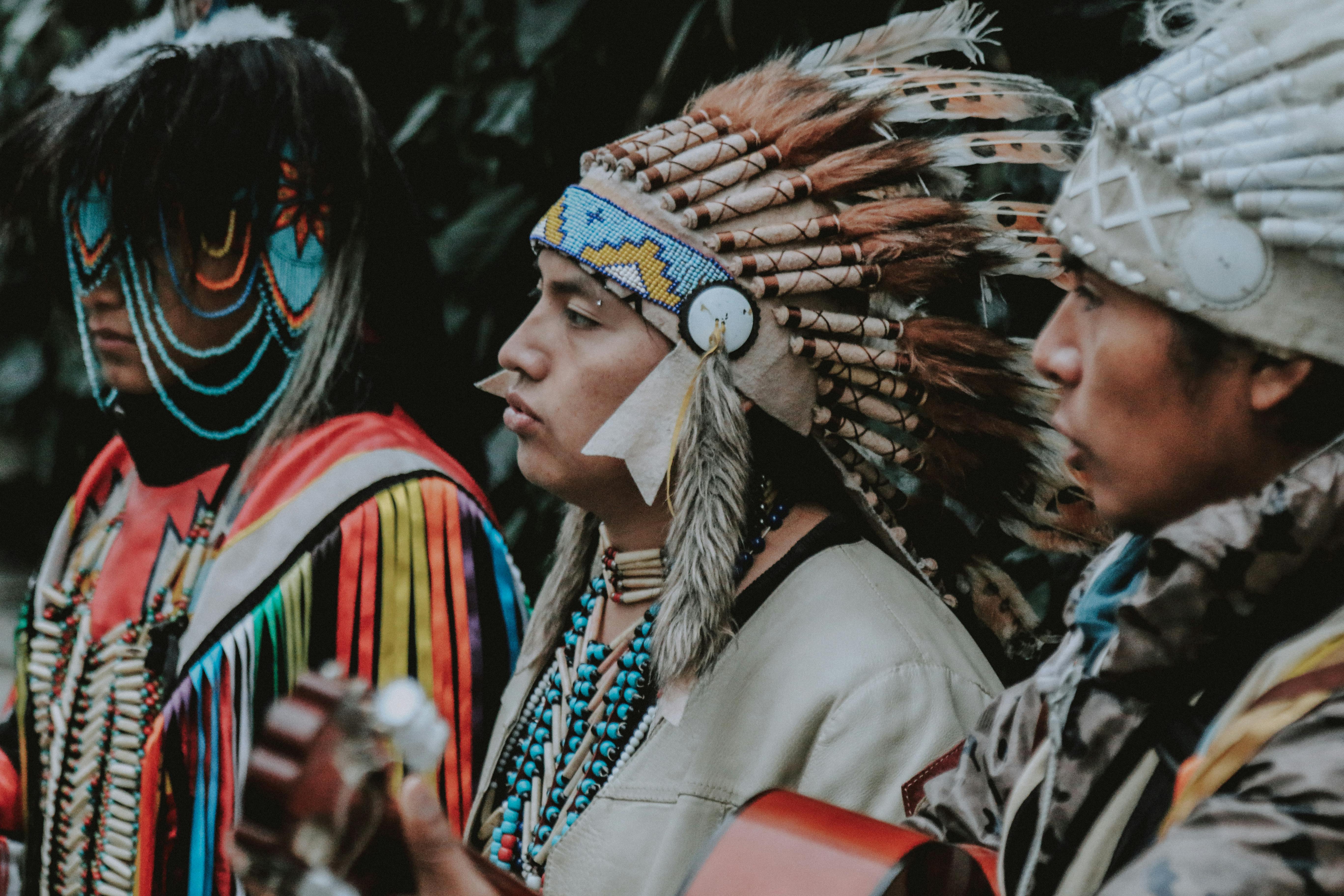 Portrait of Three Men in Traditional Native American Clothes Playing Guitar