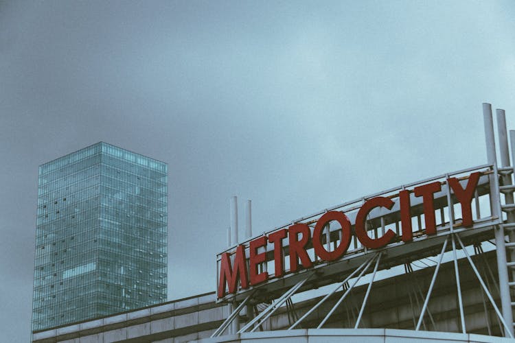 Skyscraper And Logo Under Clouds