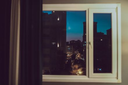 Night street seen through an open window, by Sami Aksu on Pexels