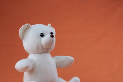 White Bear Plush Toy on Orange Textile