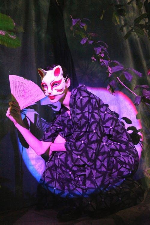 A Woman in Robe Wearing a Cat Mask