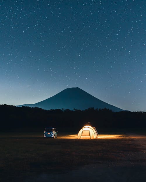 Tent under Starry Sky with View on Volcano 