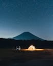 Tent under Starry Sky with View on Volcano