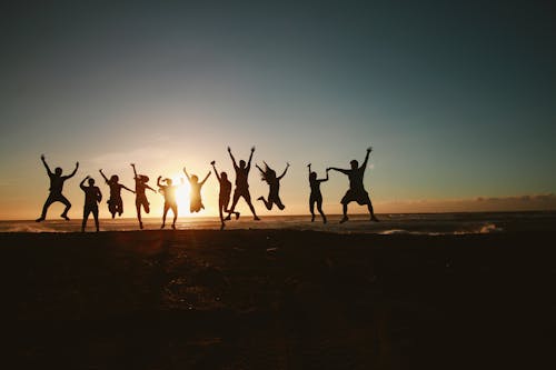 Fotografia Di Sagoma Di Un Gruppo Di Persone Che Saltano Durante Il Periodo D'oro