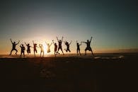 Silhouette Photography of Group of People Jumping during Golden Time