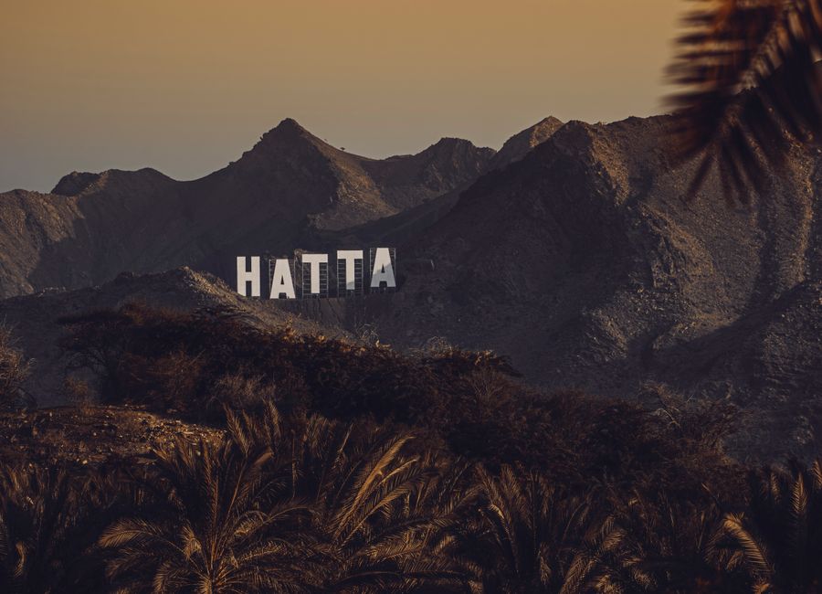 Stunning view of Hatta mountains with signage at sunset, United Arab Emirates.