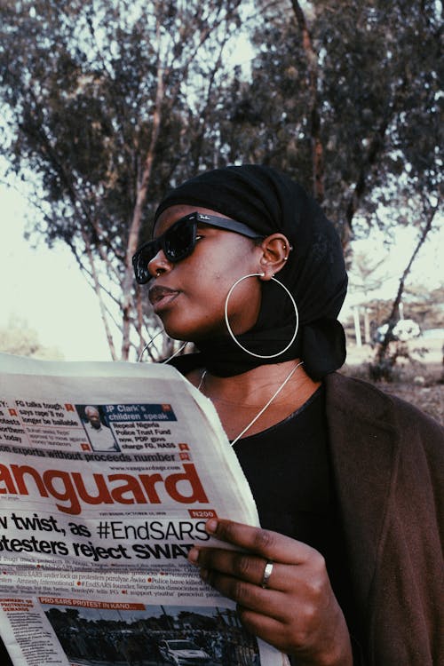 Free 
A Woman Wearing a Headscarf Reading a Newspaper Stock Photo