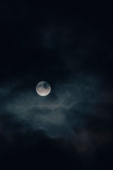 Captivating view of the full moon amidst clouds in Sweden's night sky.