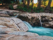 在郁郁葱葱的森林中，宁静的瀑布流过岩石，展现了大自然的美丽