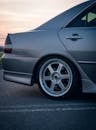 黄昏时分，一辆银色轿车停在路边，露出合金车轮的侧面图