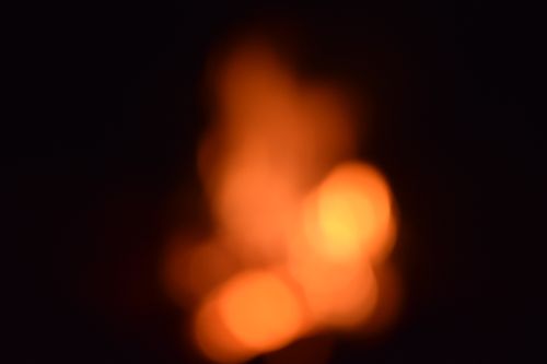 Free Blurred orange and yellow bokeh lights on a dark background, creating a warm abstract effect. Stock Photo