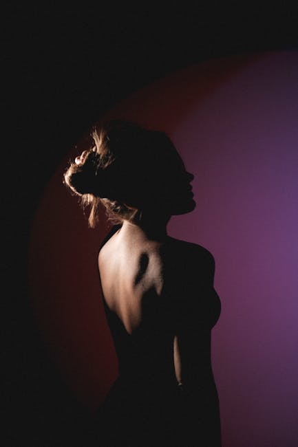An evocative silhouette of a woman captured in soft lighting, blending shadows and highlights.