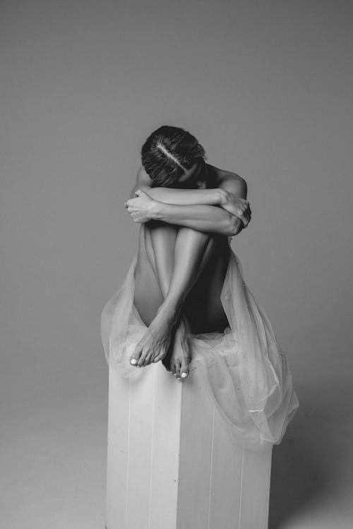 Black and White Portrait of Woman in Skirt Sitting