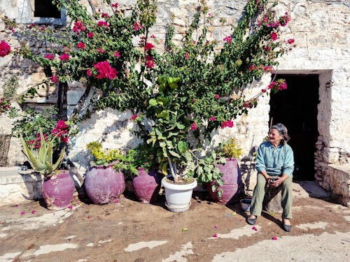 Elderly Woman Sitting Near Potted Plants