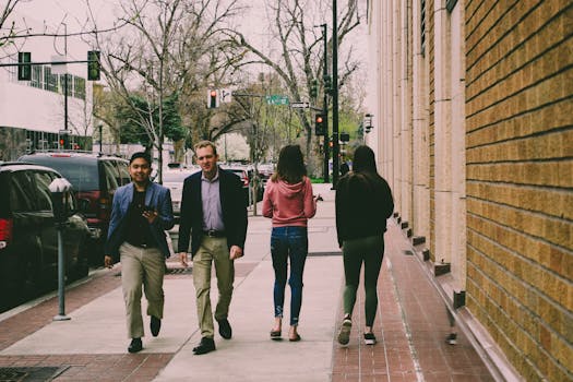 四个成年人白天走在充满活力的城市人行道上