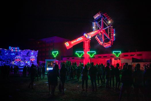 Exciting nighttime scene of a neon-lit amusement park ride, capturing the thrill and vibrant colors.