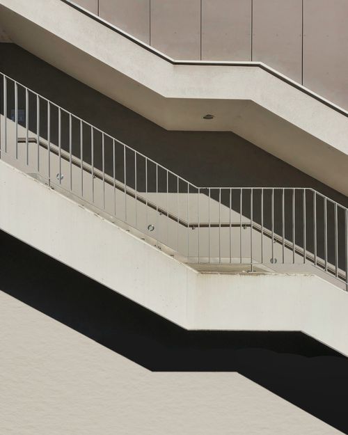 Free A sleek concrete staircase featuring metal railings in a modern architectural style. Stock Photo