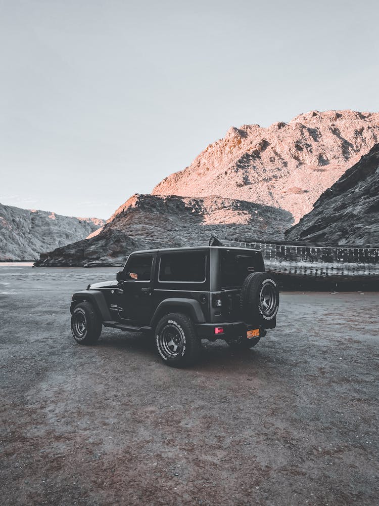 4x4 Car On Dry River Bed Next To Boat