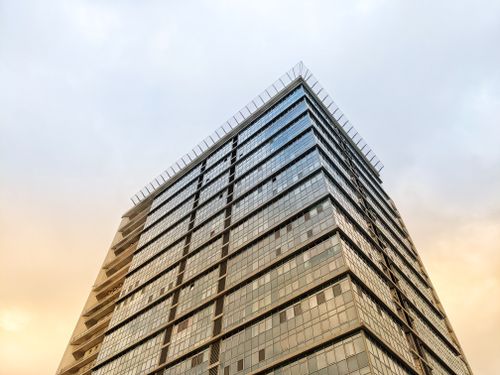 Free Low angle view of a modern skyscraper in Kyiv, Ukraine showcasing urban architecture at sunset. Stock Photo