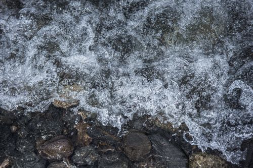 Free Capture of ocean waves crashing against rocks, creating a dramatic splash effect. Stock Photo