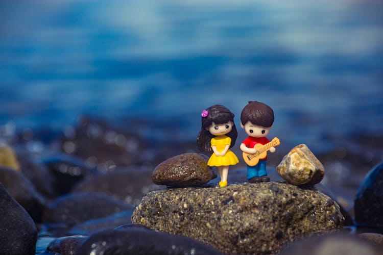 Miniature Couple Figurines On A Rock 