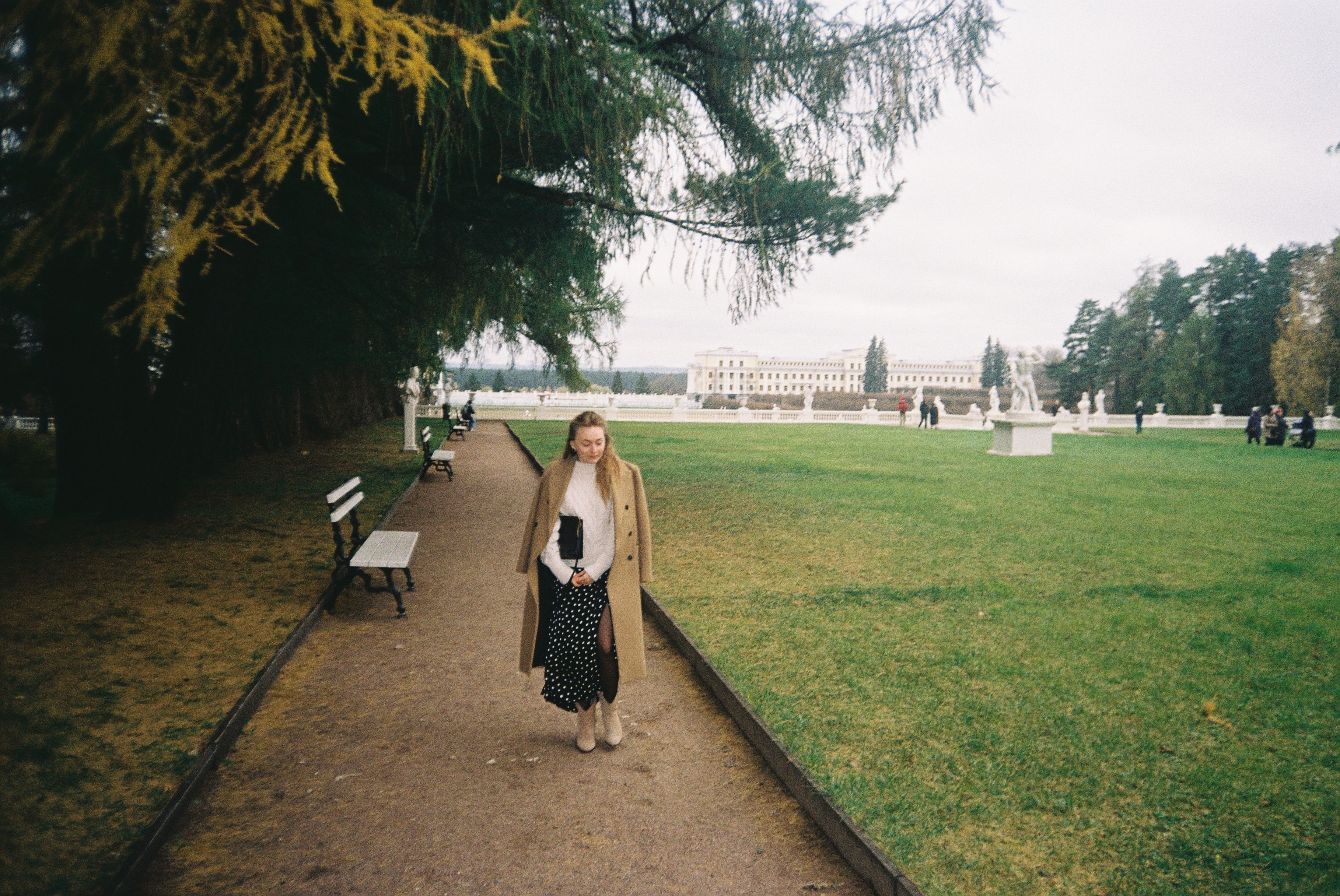 A Woman in Brown Coat Standing on a Pathway of a Park · Free Stock Photo