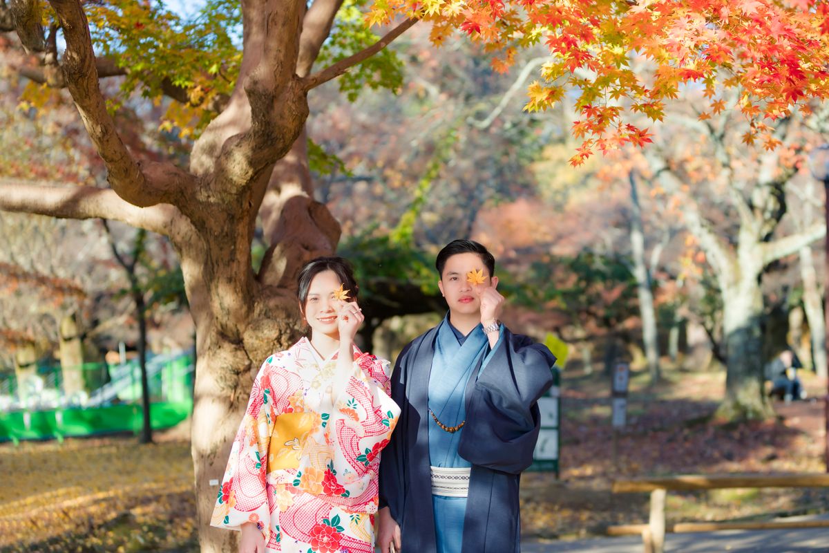 Pareja en kimono entre arces de otoño en Japón - viaje de aniversario