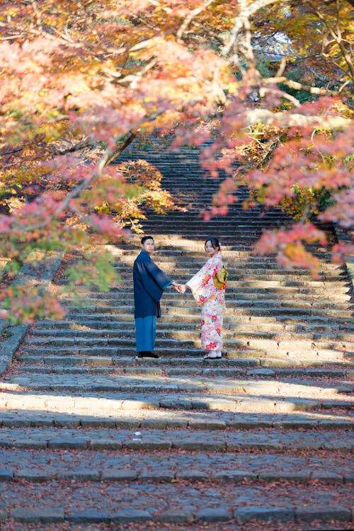 A Couple Holding Hands while Standing on the Stairs